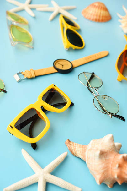 moderne modische Sonnenbrille und Sandalen mit Seesternen als Hintergrund - Foto, Bild
