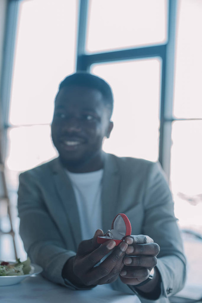 selective focus of african american man with wedding ring at table in restaurant - Photo, image
