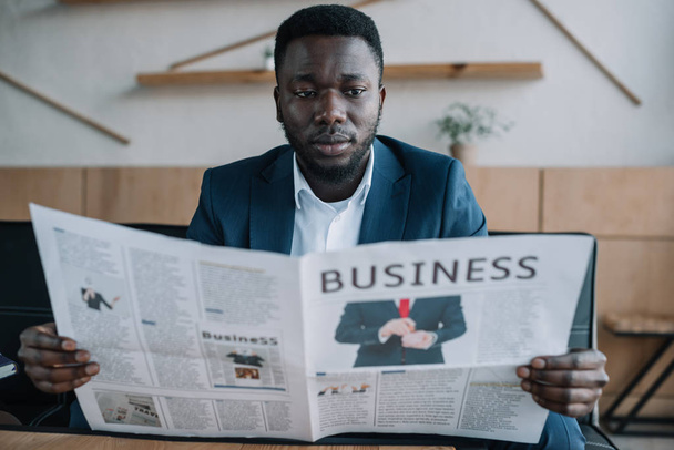 portrait of african american businessman reading newspaper in cafe - Foto, Imagem