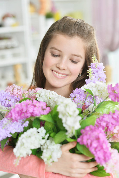 Niña feliz posando en casa con flores
 - Foto, imagen