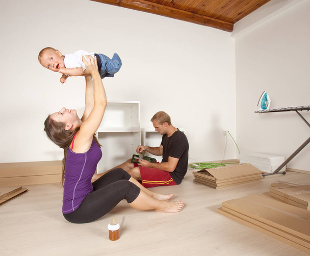 Young Family with a Baby Moving to New Apartment - Foto, afbeelding