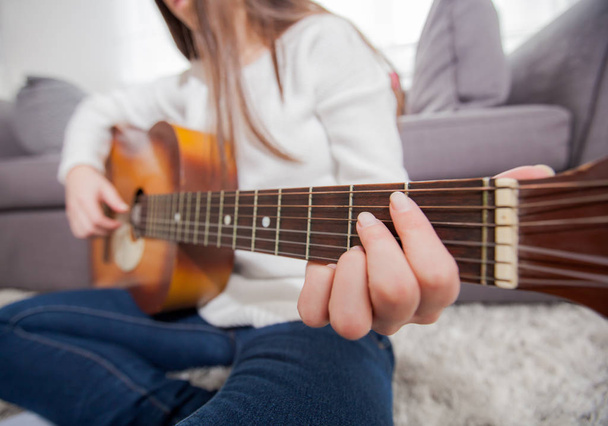 Női kéz játszik akusztikus gitár otthon, tehetséges felismerhetetlen zene nő   - Fotó, kép