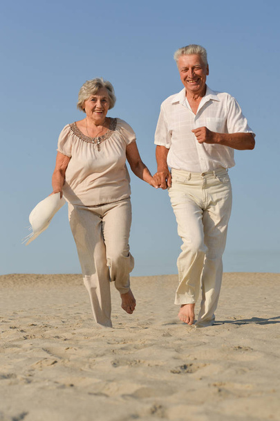 senior couple run on  the sand in the summer - Foto, Imagem