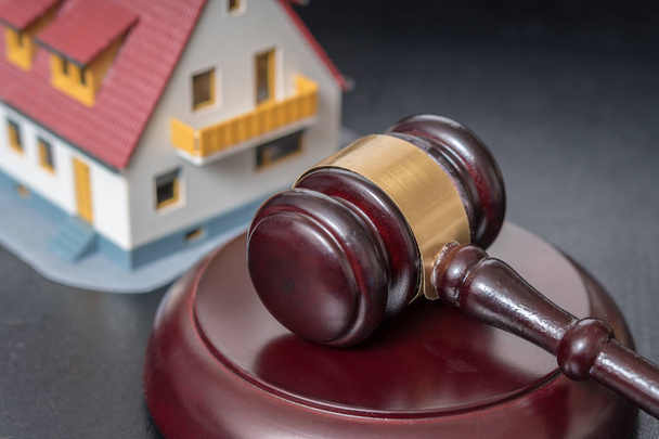 House auction concept. Gavel in front of a house model. - Photo, Image