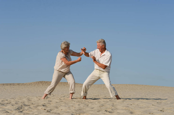coppia anziana che combatte sulla sabbia in estate
 - Foto, immagini