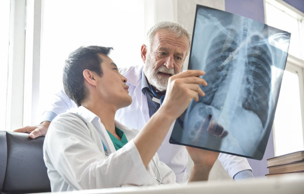 Senior Male and Young Asian man doctors are examining x-ray film - Foto, Bild