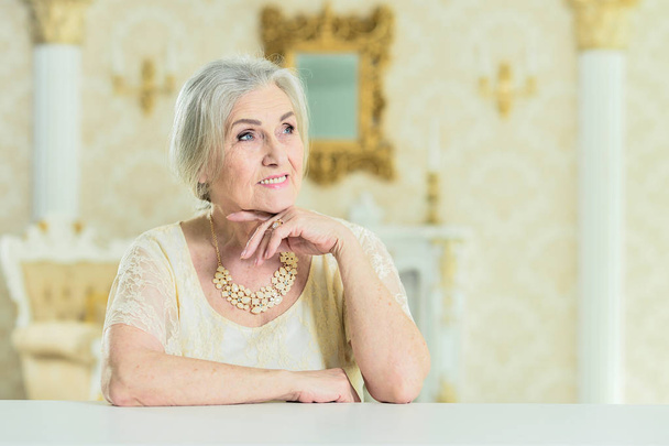 Portrait of beautiful senior woman with jewelry posing at home - Zdjęcie, obraz