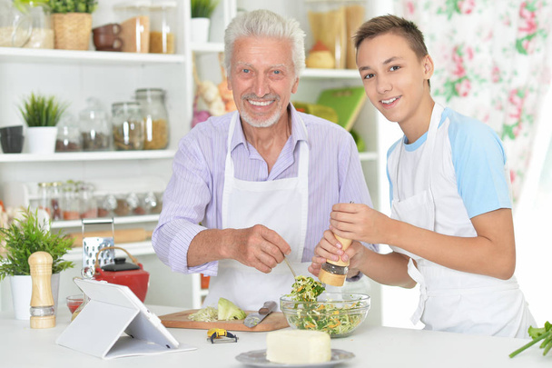 Senior man with grandson preparing dinner in kitchen - Fotografie, Obrázek