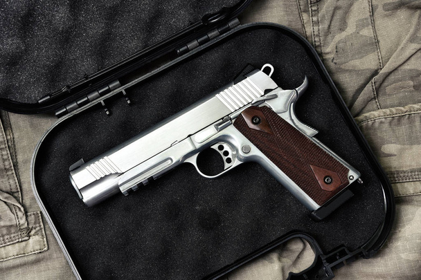 Pistolet, 11mm, Seria broń pistolet, zbliżenie pistolet policja na tle kamuflażu. - Zdjęcie, obraz