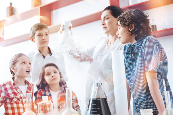 Female chemist showing fuming flask her little scientists - Photo, Image