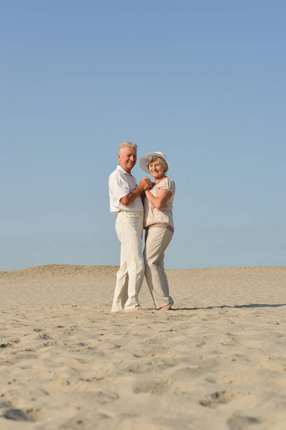 pareja mayor enamorada bailando descalza en la arena
 - Foto, imagen