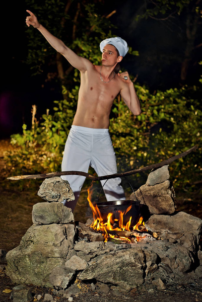 A man in a cooks suit near the fire - Foto, imagen