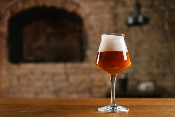 vista ravvicinata di birra fresca fredda in vetro su tavolo di legno in bar
 - Foto, immagini