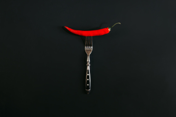 red hot chili pepper on fork on black - Photo, image