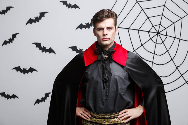 Koncepcja Halloween Wampir - portret przystojny Wampir kaukaski w czarny i czerwony kostium halloween. - Zdjęcie, obraz