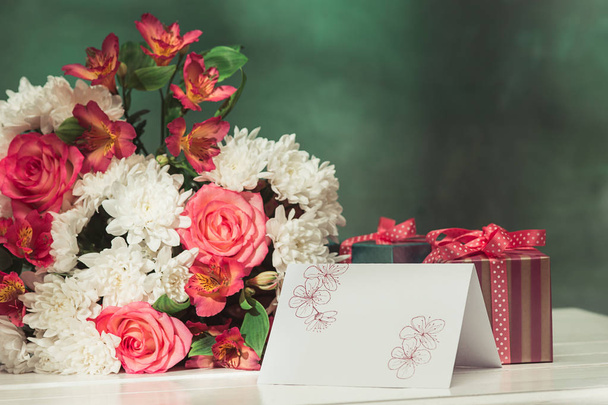 Love background with pink roses, flowers, gift on table - Fotó, kép