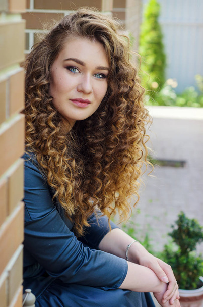 Portrait of a beautiful cute girl with chic curly hair against a - Foto, immagini