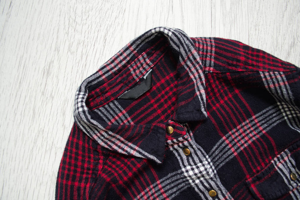Checkered shirt, close up. Wooden background. Fashionable concept - Foto, Bild