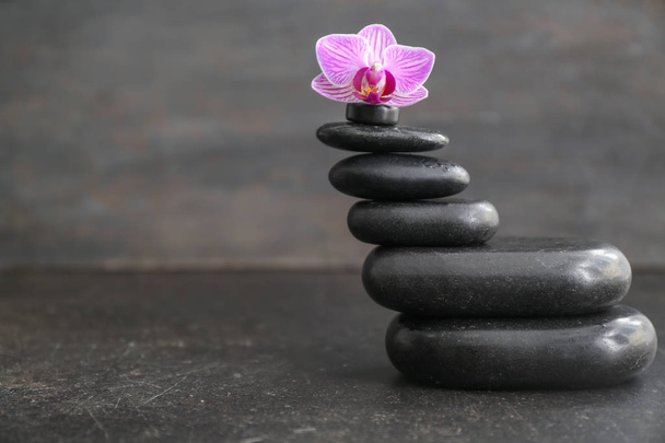 Stack of spa stones and beautiful orchid flower on table - Photo, Image