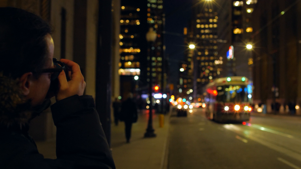 Erkek fotoğrafçı alarak fotoğraf şehrin geceleri sokak  - Video, Çekim