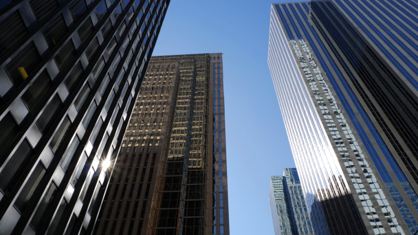 Наклон, чтобы показать высокие офисные здания в центре города в солнечный день
 - Кадры, видео