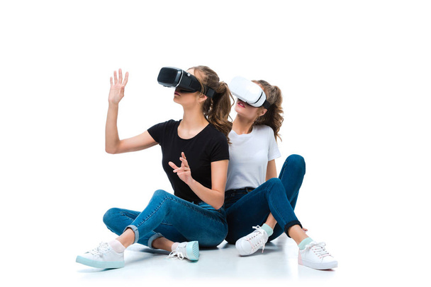 Junge Zwillinge berühren etwas mit Virtual-Reality-Headsets auf Weiß - Foto, Bild