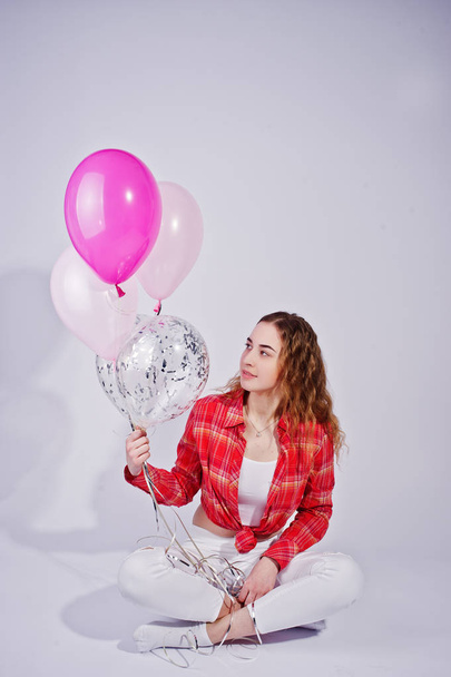 Young girl in red checked shirt and white pants with balloons ag - Фото, зображення