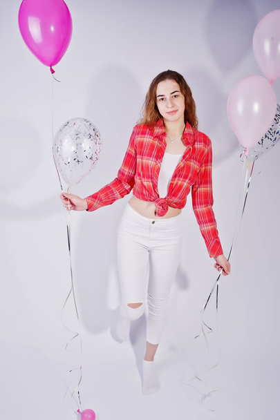Young girl in red checked shirt and white pants with balloons ag - Foto, immagini