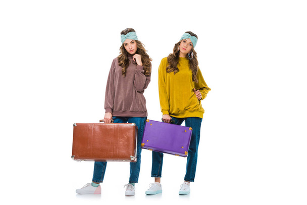attrayant jumeaux de style rétro debout avec des sacs de voyage isolés sur blanc
 - Photo, image