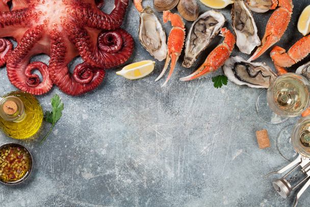 Meeresfrüchte. Kraken, Hummer, Venusmuscheln. Draufsicht mit Weißwein auf Steintisch mit Platz für Ihren Text - Foto, Bild