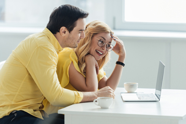 男と女がコーヒーを飲みながら、ノート パソコンの画面を見て - 写真・画像