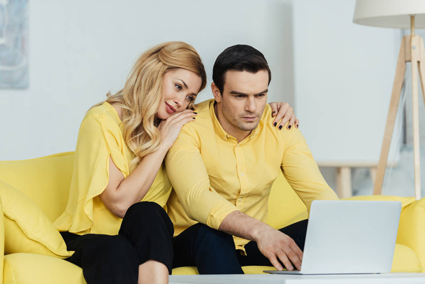 Femme blonde étreignant son petit ami travaillant sur un ordinateur portable
 - Photo, image