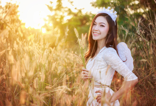 angel woman in a grass field with sunlight - Photo, Image