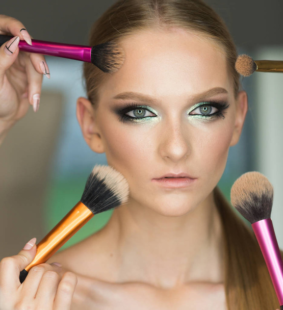 Woman getting powder on skin with brushes, makeup. Hands apply makeup on model face. Woman with young face in beauty salon. Visage course, professional make up. Girl with healthy skin, skincare - Valokuva, kuva