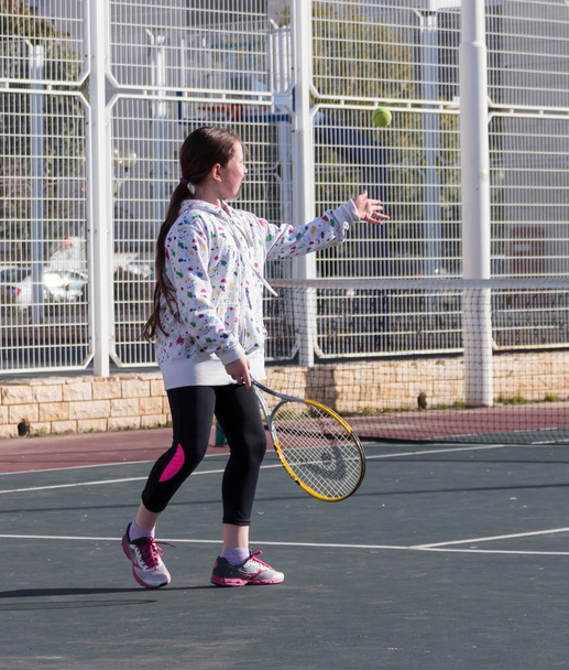 Holka hraje tenis na kurtech a udeří míč raketa - Fotografie, Obrázek