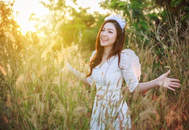 Άγγελος γυναίκα σε ένα χόρτο πεδίο με το ηλιακό φως - Φωτογραφία, εικόνα