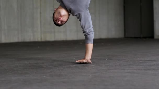 Young man showing dancing elements of breakdance  - Filmati, video