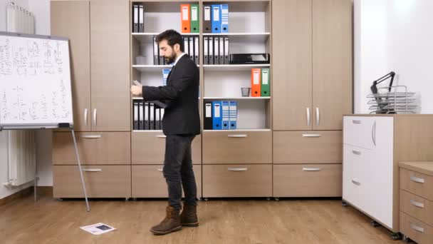 Stressed businessman throwing papers from a folder on the floor - Video