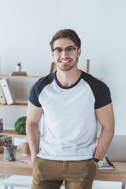 cheerful man in casual clothes and glasses smiling at camera - 写真・画像