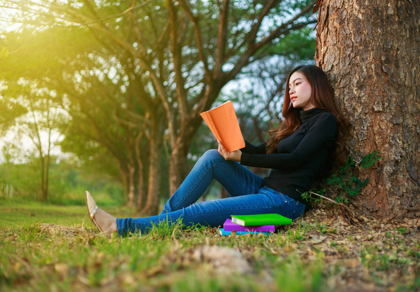 young woman sitting and reading a book in park - Foto, Imagem