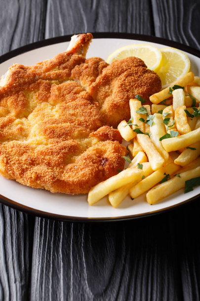 Traditional Italian veal Milanese with lemon and French fries cl - Photo, Image
