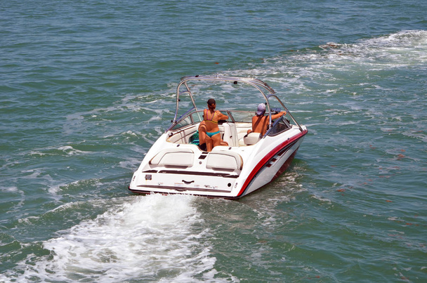 Due ragazzi e una giovane ragazza in bikini che si godono una crociera domenicale pomeriggio in barca a motore sulla florida via d'acqua intra-costiera al largo di Miami Beach
. - Foto, immagini