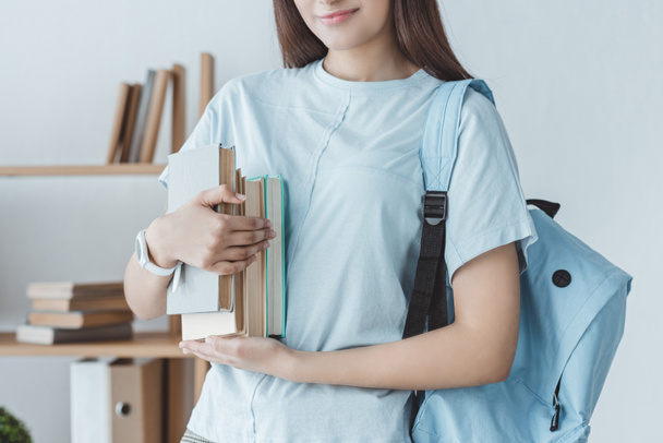 cropped view of girl with backpack holding books - Фото, зображення