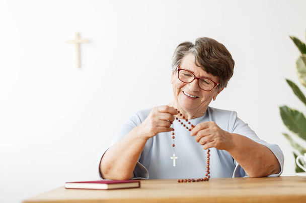 Smiling senior woman with rosary - Foto, afbeelding