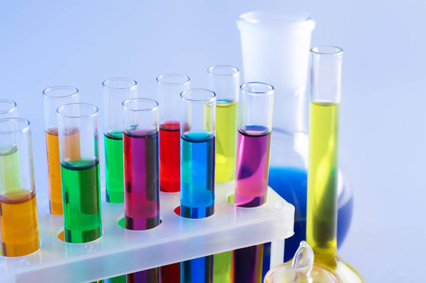 Chemical glassware with colorful samples on light background - Fotografie, Obrázek