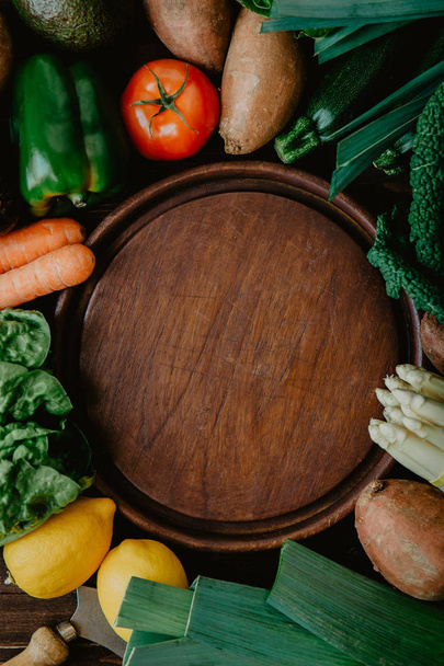 Assiette en bois entourée de légumes frais
 - Photo, image