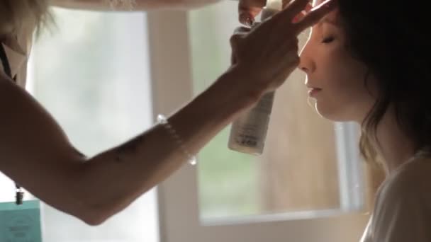 Hairdresser hands using hairspray on client hair - Záběry, video