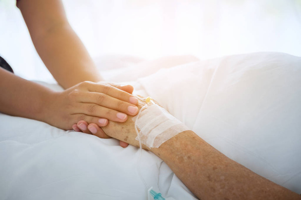 médecin Holing mains de la patiente âgée et la réconforter
, - Photo, image