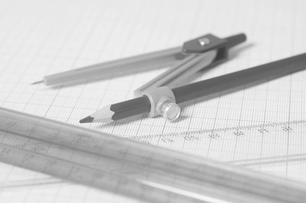 Drawing compass with black pensil  and rulers on graph paper. - Photo, Image