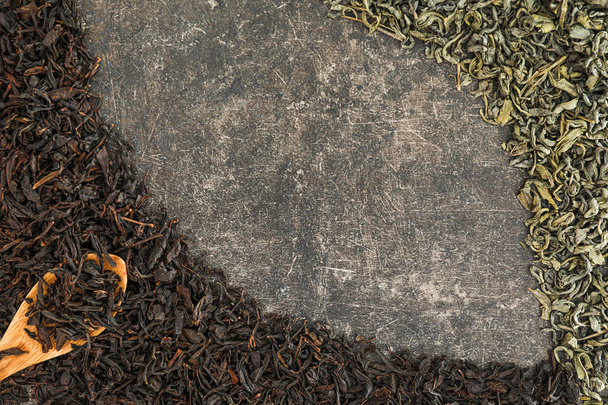 Zöld és fekete tea levelek száraz kanállal a szürke háttér - Fotó, kép